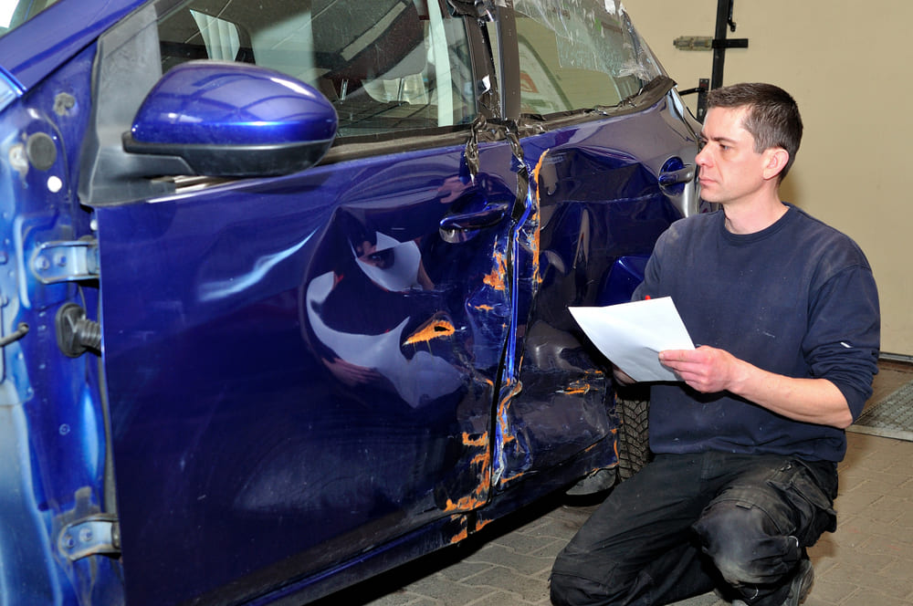 Car insurance auto body repair claim being reviewed after accident