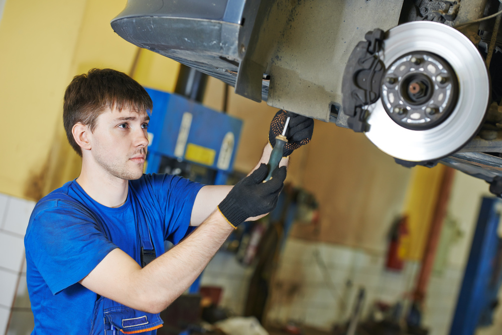 Customer inspecting car damage caused by an auto body shop in Brooklyn NY during collision repairs