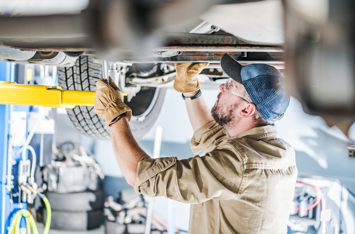 Frame straightening in Brooklyn, NY technician inspecting vehicle undercarriage at Cyclone Collision Center