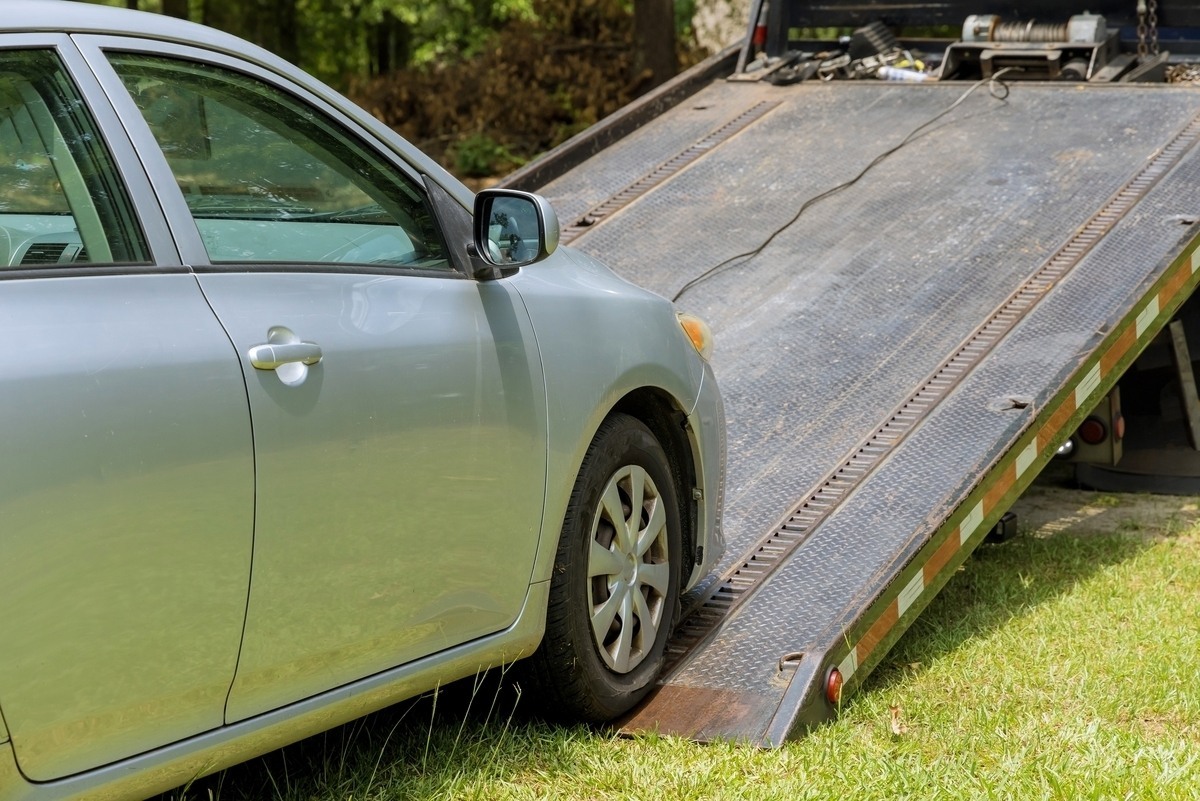 Car being loaded onto a flatbed truck for towing service in Bay Ridge
