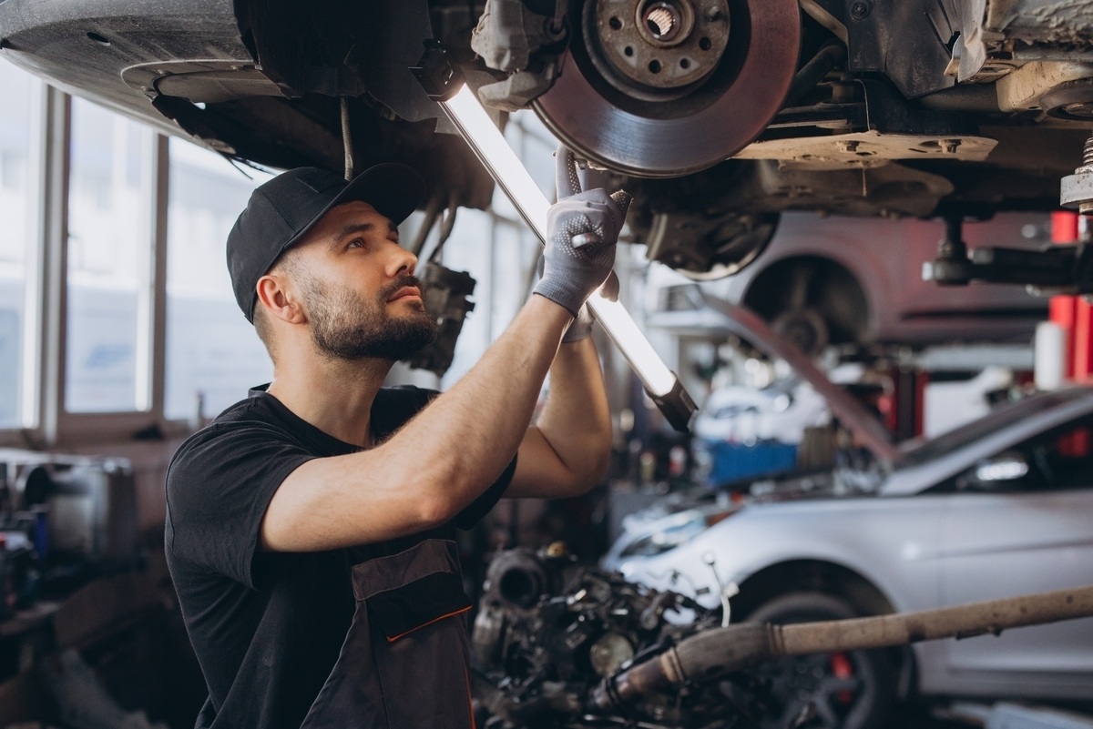 Suspension repair in Gravesend, NY: mechanic inspecting brake and suspension components at Cyclone Collision Center